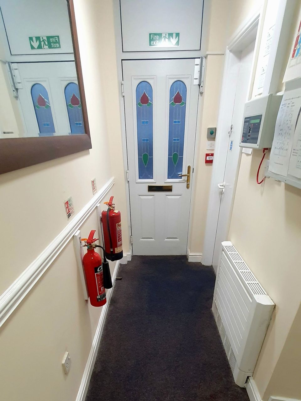 The hallway and front entrance, with fire door and notice board