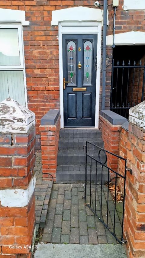 The front door of number 6, with steps up from a gated path