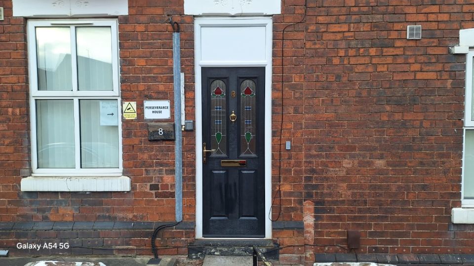 The front door of number 8, with the Perseverance House sign beside it